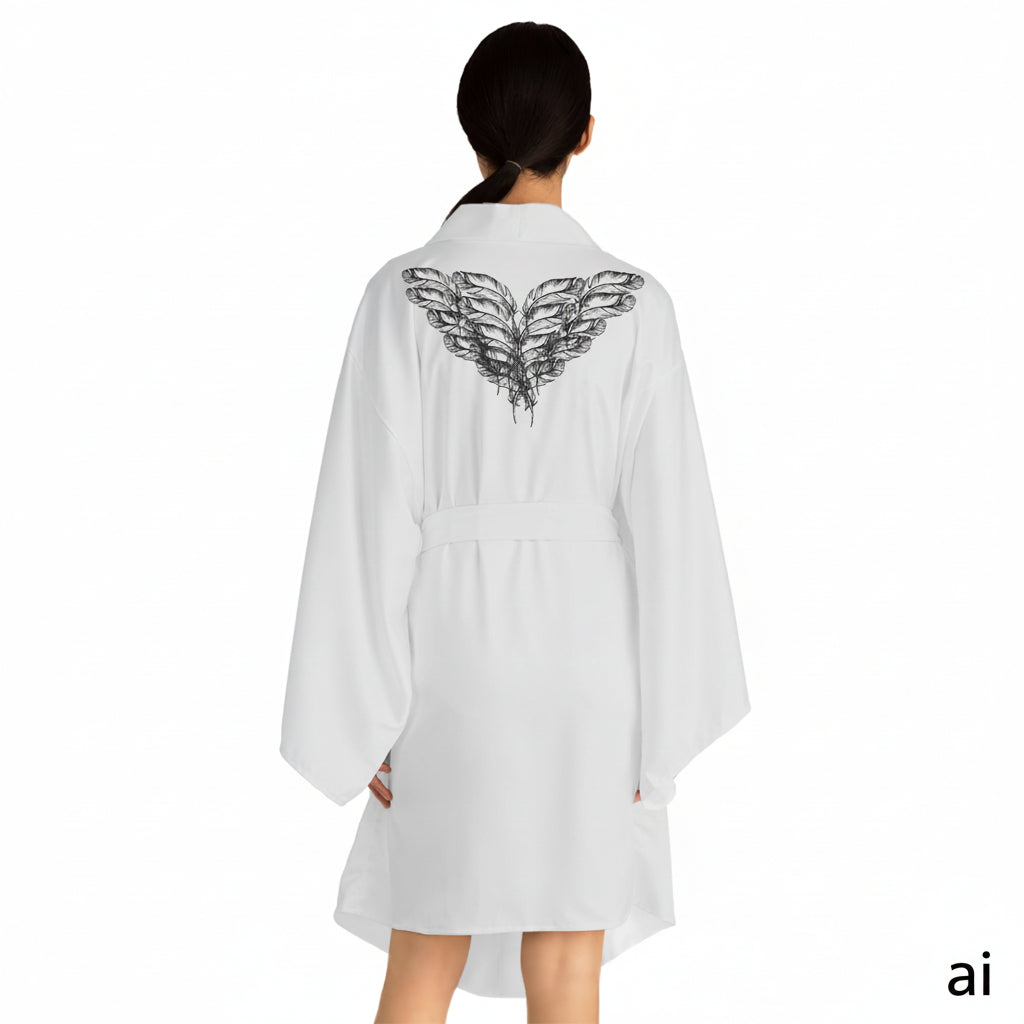 Back facing woman wearing the moontiq white kimono robe 'I Got Wings' with black angel feathers on the sleeves against a white background