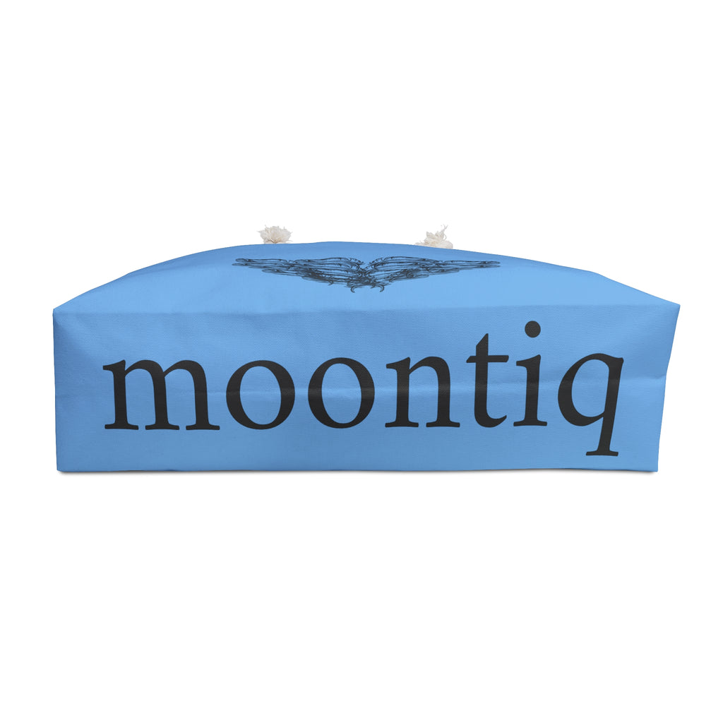 moontiq branding on the bottom of the 'I Got Wings' large angelic blue tote bag with an angel wing design on the sides of the weekender bag with white rope handles on a white background