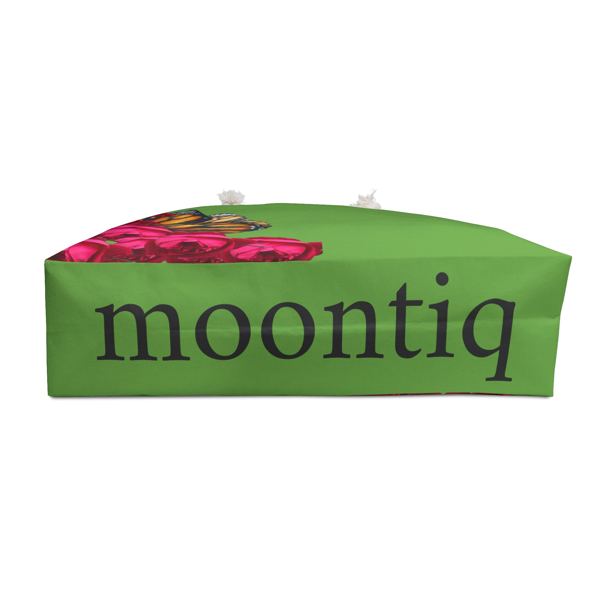 'moontiq' branding on the bottom of a large green weekender tote bag with butterflies and pink roses with a white background